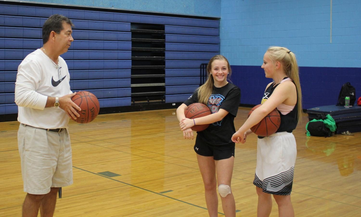  Girls basketball Coach David Kontny gives advice to freshmen Paige Tollefson and Macie Tuura  at open gym Wednesday. 
