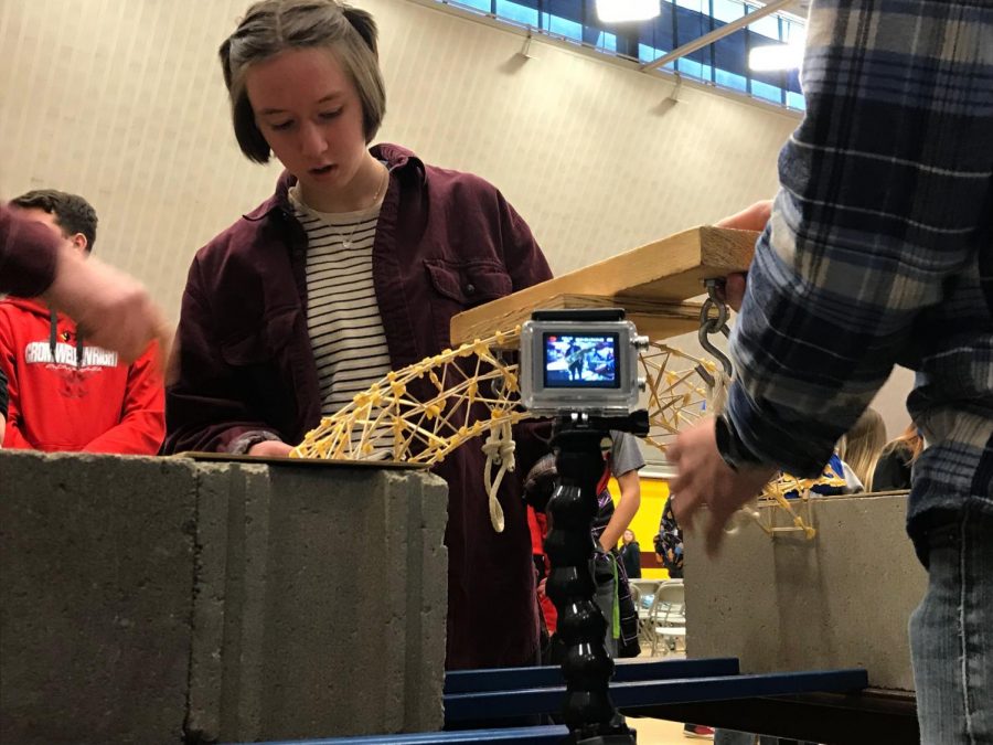 Junior Amelia Evavold scoops sand into the bucket attached to her bridge. Her bridge held up 18.35 kilograms (40 pounds)