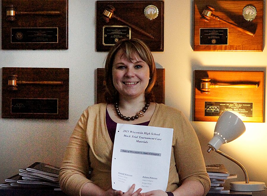 Mock trial coach Danielle Gondik-Anderson poses with the older case and mock trial awards.
