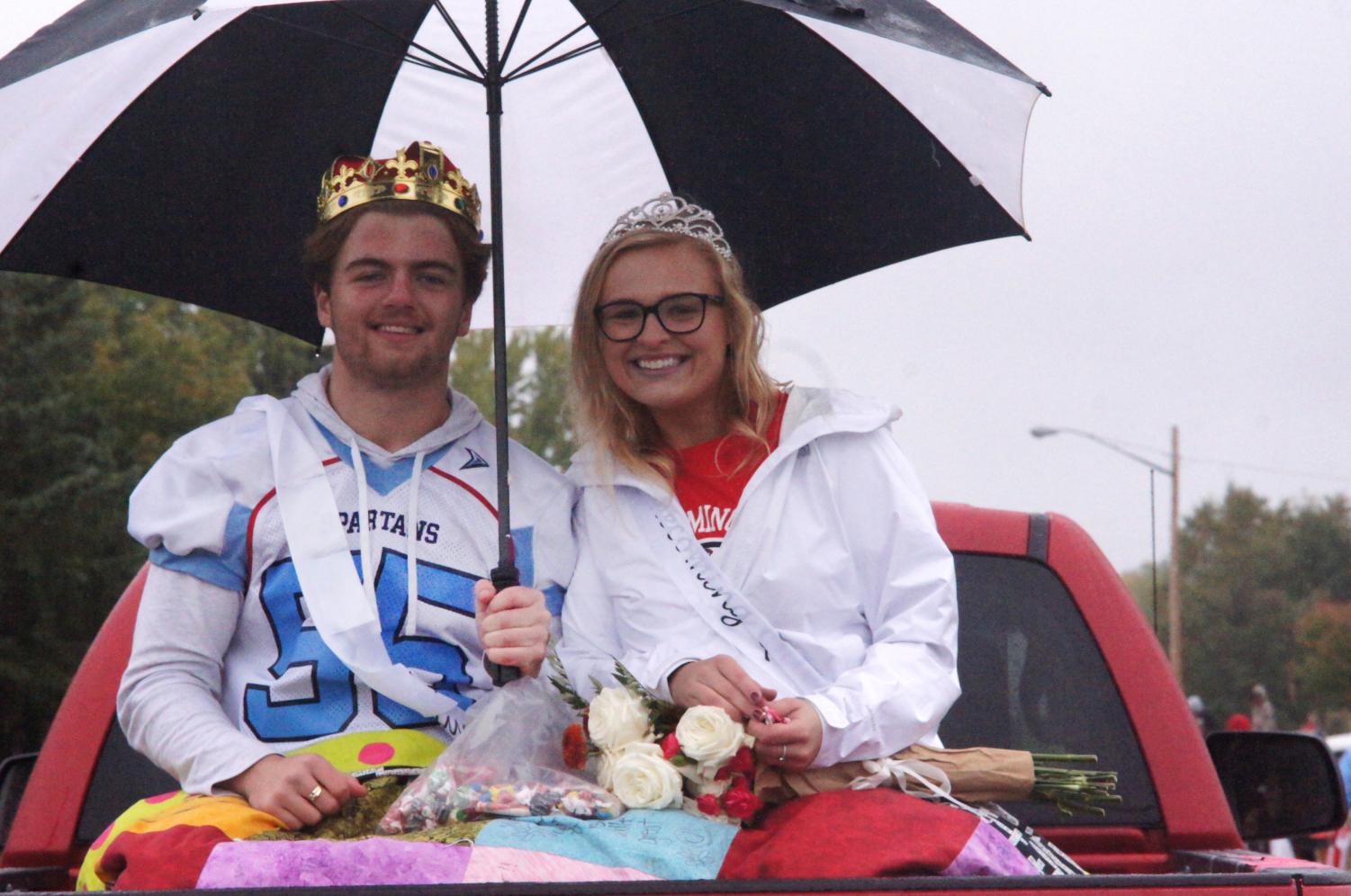 Homecoming queen and king Mady Stariha and Lars Root pose for a photo during the Homecoming parade while throwing candy to the spectators on Oct 5.
