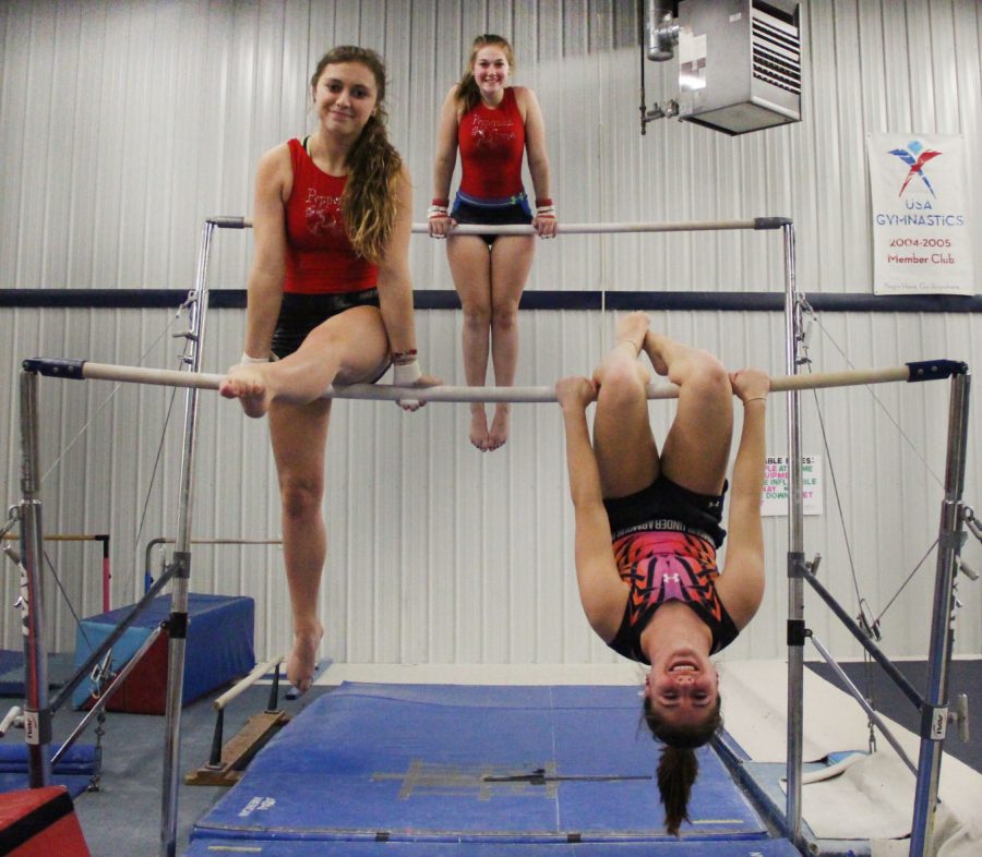 Left to right, Sophomore Reese Deyo (Superior), Sophomore Kylie Benesch (Northwestern), and Sophomore Adrianne Krueger (Superior) on the uneven bars practicing with the co-op team. 
