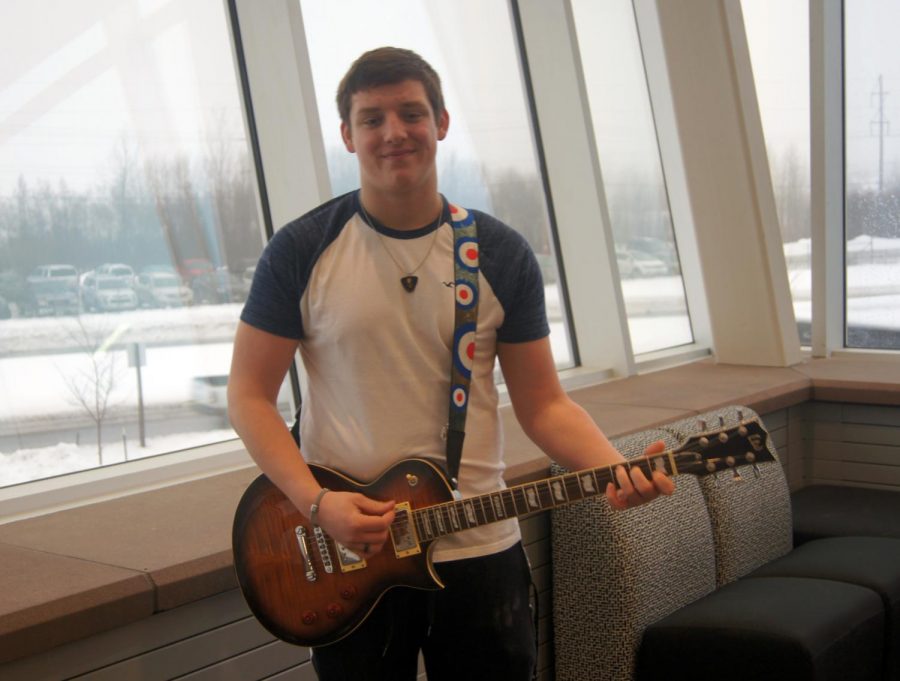 Dylan Evavold strumming his guitar on the second floor balcony on Dec. 7.  
