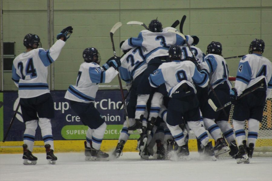 Spartan Boys Hockey team jumping to joy after tremendous victory over defending state champion Hudson Raiders, as Paige Hansen capture her favorite photo on Dec. 1, at Wessman Arena.
