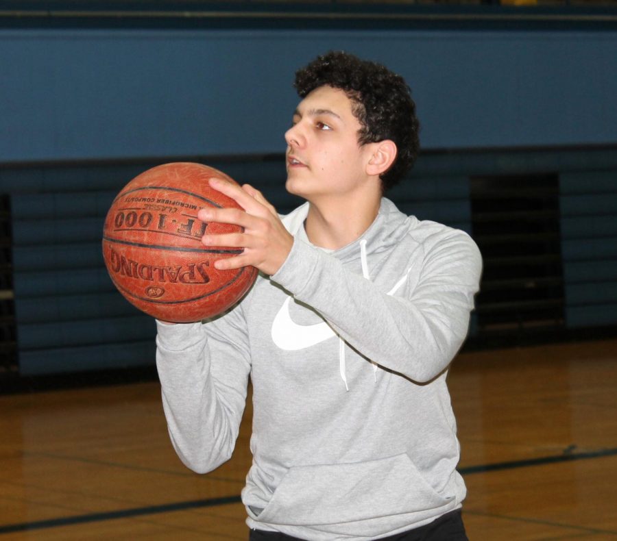 Sophomore Malachi Simiyu practices shooting in SHS gym on Feb. 15. He measures his improvements made from the Fitnessgram testing in his gym class.