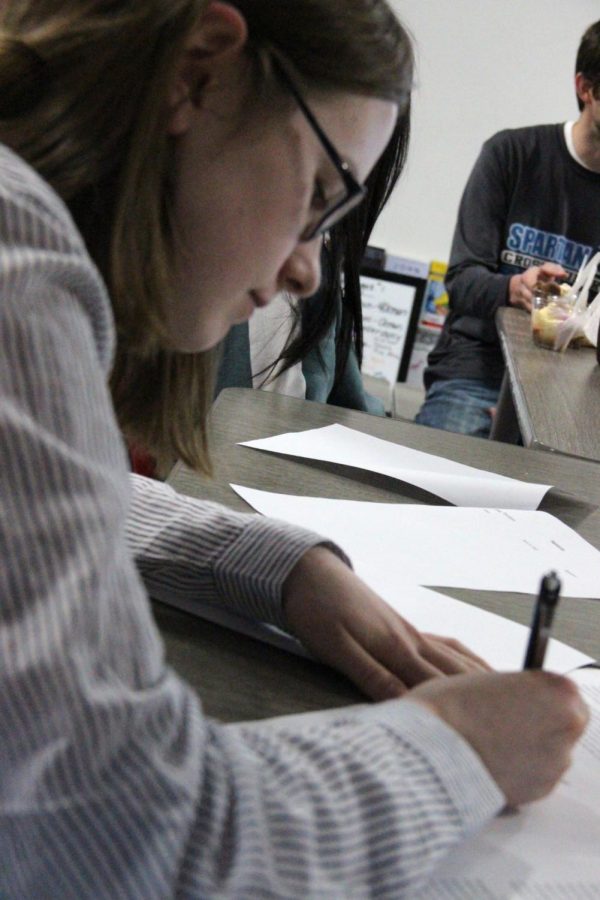 Senior Lora Randa, president of the Amnesty International club signs letter to the school board addressing the policy in room 1590 on March 22.