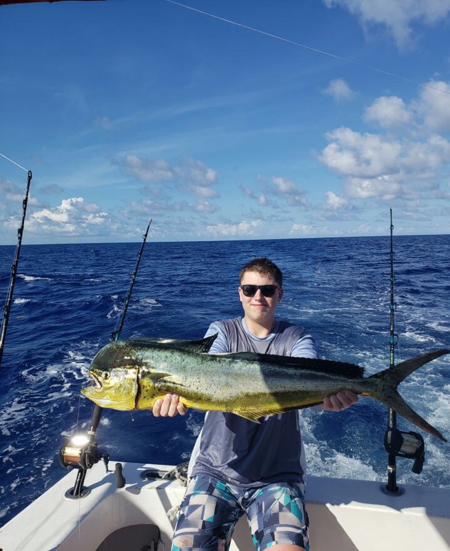 Junior Luke Wessberg poses for a picture in the Dominican Republic holding a 4 foot Mahi Mahi. Wessberg continues to fish for the family time, fun and the thrill of getting big fish like this one on March 14.