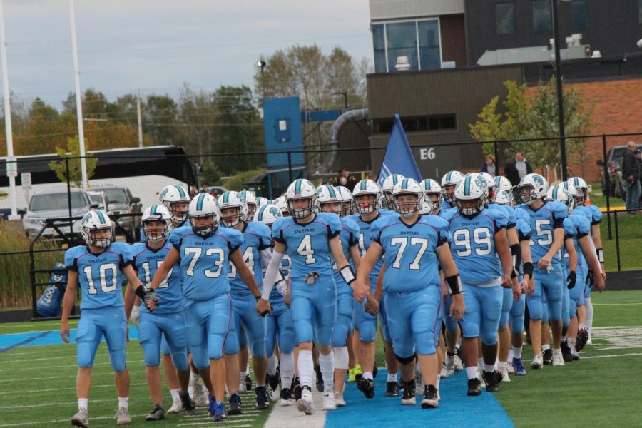 Seniors+Brennan+Morrissey+%2810%29%2C+Brock+Bergstrom+%2873%29%2C+Brady+Herbst+%284%29%2C+Luke+Persons+%2877%29+lead+the+Spartan+football+team+onto+the+field+to+play+the+Chippewa+Falls+Cardinals+in+the+2019+Homecoming+game.