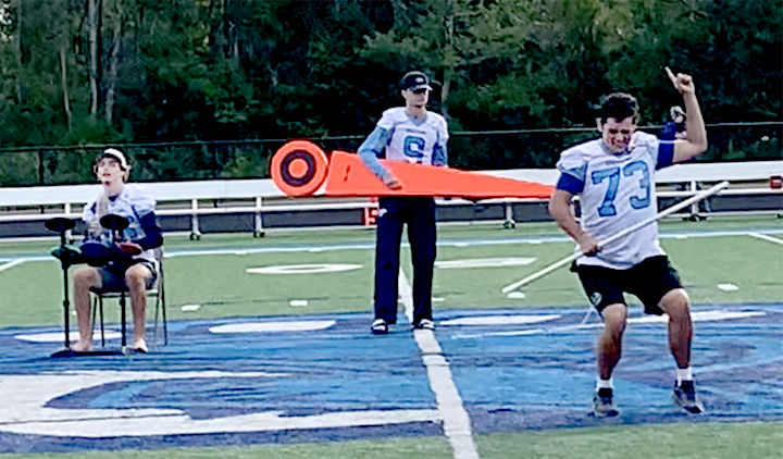 Senior Brock Bergstrom (73) dances while Junior Jake Edwards plays drums along with Ben Hunter (9) using a line marker as an air guitar Sept. 7. Throughout the fall season, they played at the Superior’s Youth Football games during halftime on the NBC Sports Complex field.
