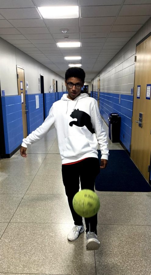 Freshman Darrell James kicks a soccer ball in the gym hallway Nov. 11. James says that he looks up to professional soccer player Lionel Messi. 