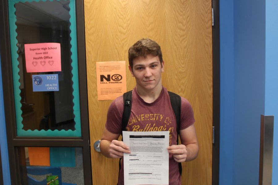 Junior P.J. Kerr stands outside of the Nurses Offices after he grabbed an Authorization to Administer Medication/Procedure Consent Form. He will need to bring this form home to his parents to get signed in order to bring in Tylenol to treat his pain. 