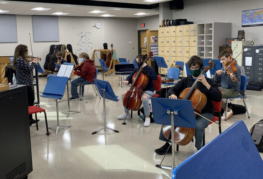 Orchestra Director Amy Eichers is conducting the Orchestra Students in class as well as the online students with her computer on Tuesday, September 29. Students in the class are wearing masks and social distancing.

