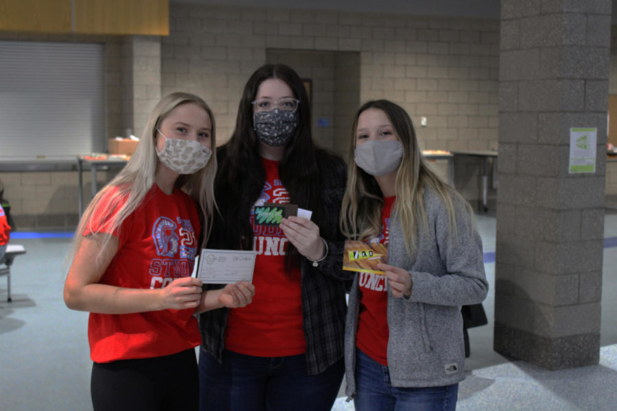 Senior Student Council President Faith Lach (right) is standing next to senior Mara McGillis (middle) and senior Sydnie DeMeyer (left) getting ready for the Movie Trivia Night Kahoot questions on Tuesday Mar. 29. 