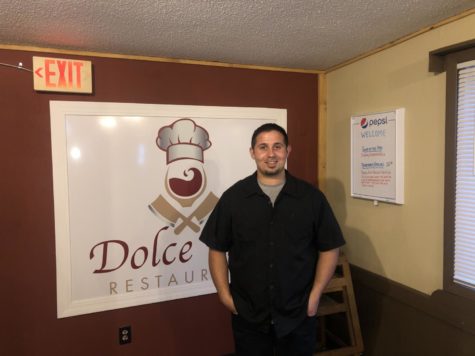Chef and Owner Zudija Maksutoski stands on the right side of the Dolce Vita sign. 