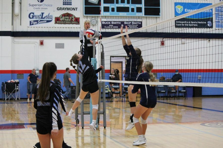 JV player Indigo Fish blocks the ball over the net at the game. Fish really helped the team out at their very first game.