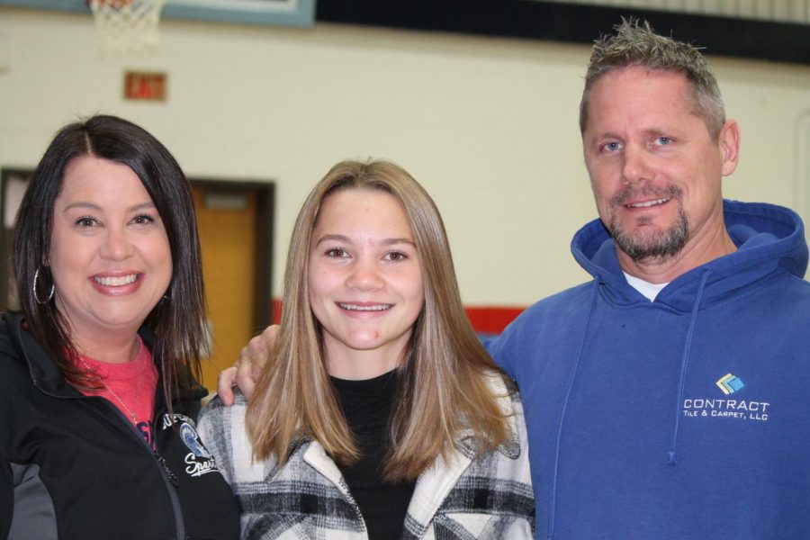 Tayler McMeekin poses with her parents after receiving a state send off to cross country which took place over the weekend on October 30. McMeekin finished 19th out of 139 girls.