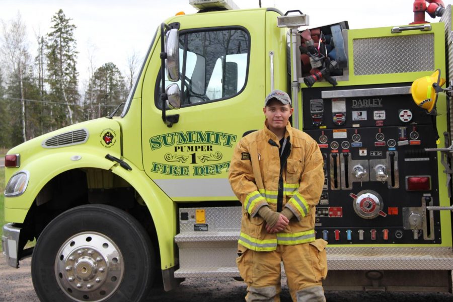 Senior Anthony James stands by Summit Volunteer Fire Department’s pump truck, Oct. 24. James devotes his free time to the Volunteer Fire Department.
