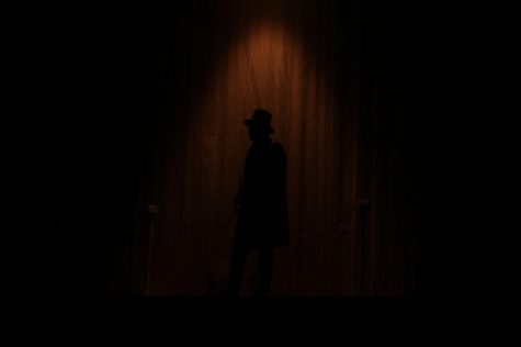 English teacher Andy Wolfe as Scrooge standing on stage.