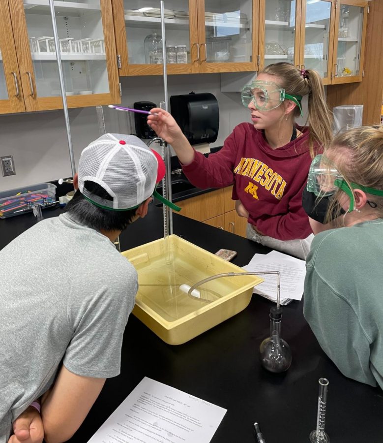 Senior Alexis Holden indicates the water level in a Eudiometer to labmates senior Kennedy Flowers and senior Tristan Brennan on Oct. 14.