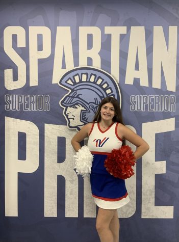 Senior Addy Ranta stands in front of the Spartan Pride wall in her nationals uniform by N3 doors on Nov. 17. Ranta is preparing for the Pearl Harbor Memorial Parade in Hawaii. 