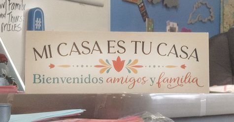 A sign reading “my home is your home, welcome friends and family” in Spanish sits on Spanish I teacher Allison Conley’s desk.