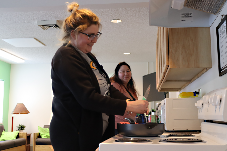 Tanya Nelson, supervisor of Project Reach Out, and Katie Modin, homeless/runaway youth coordinator, laugh and talk while cooking spaghetti dinner for youth at the group’s drop-in center on Monday, Feb. 6, 2023.
