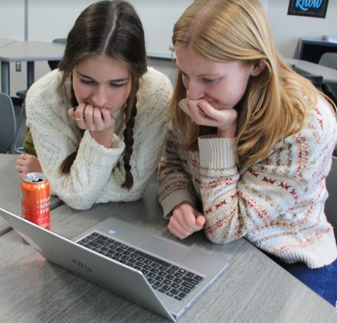 Seniors Ava Denninger (left) and Maddy Verdoljak wait by their laptop in the queue for tickets Nov. 16.