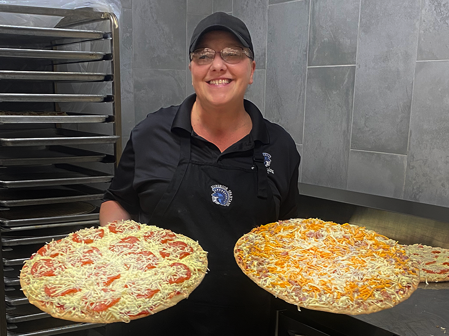 Pizza chef Melissa Young poses with pizza ready to be passed through the new pizza oven in the cafeteria Nov. 9, 2022. 