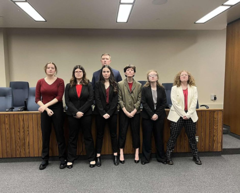 The varsity Mock Trial team strikes a pose inside the courtroom where they placed first in the competition in Eau Claire. Feb. 5, 2023.