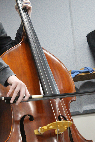Student bows along the A string on a String Bass in the orchestra room on Mar. 3.
