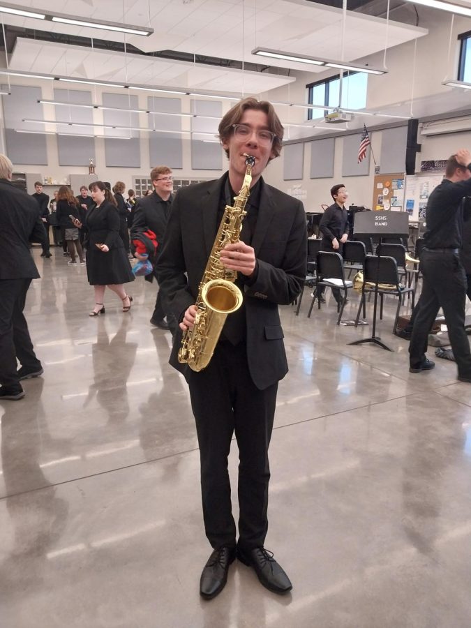 Aidan Robbins poses with his saxophone after his band performance on May 16.