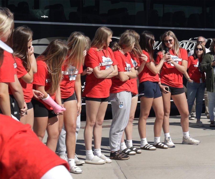 Emma Raye (right) passes a microphone to Ava Stratton as the Softball team introduces themselves during their state send-off on Wednesday, June 7.