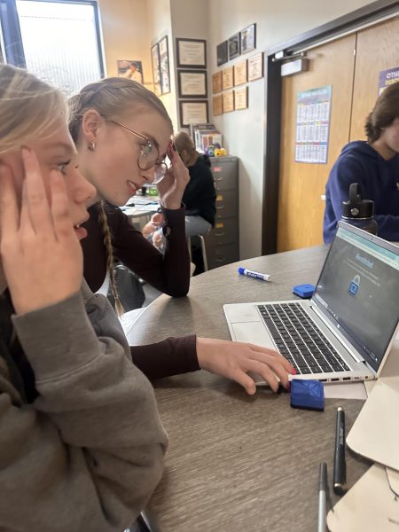  Junior Emma Ferg in the front, Sophomore Rylie Tepsa observes the computer block for Snapchat in class on November 14
