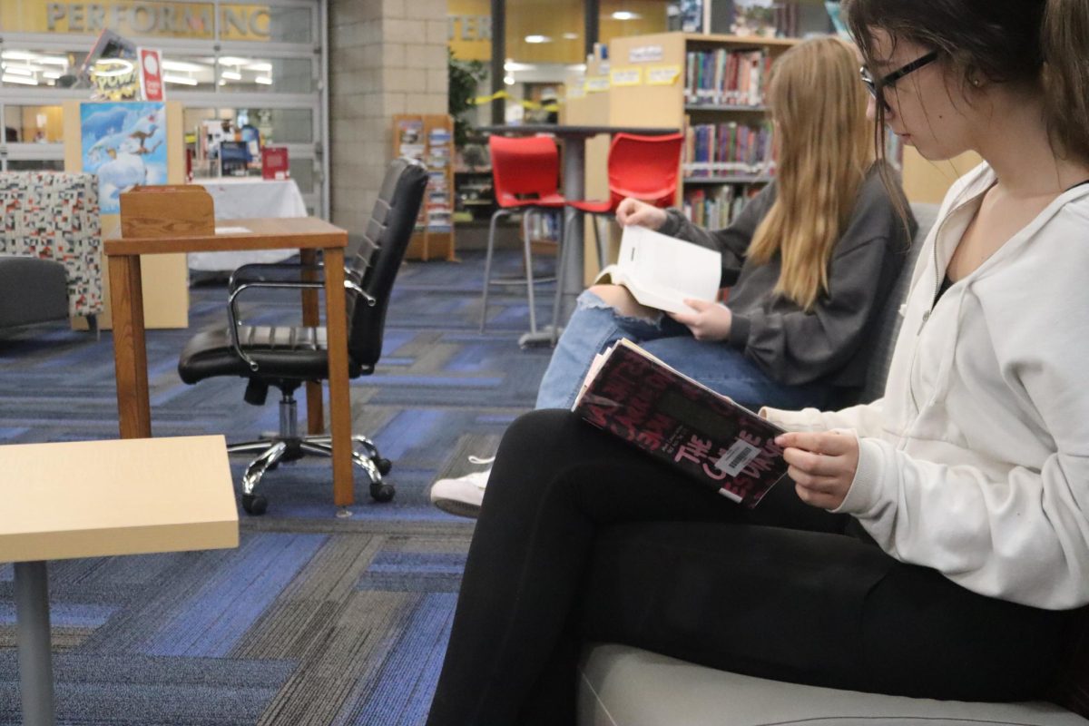 Juniors Mariah Miller and Chloe Neylon read books in the library 