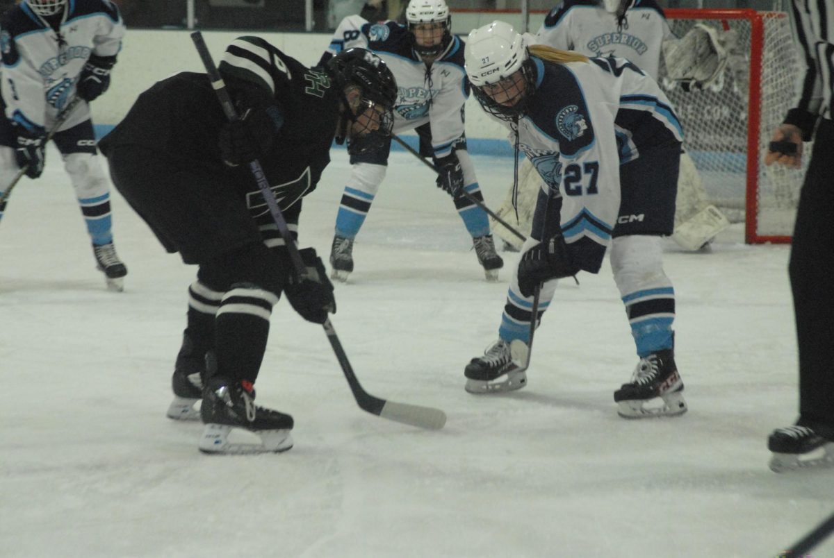 Spartans sophomore center Adalyn Benson (27) faces off against Mirage junior forward Hannah Graves (6) at the Superior Ice Arena on Jan. 29, 2024. Benson went on to score a goal in the first period.