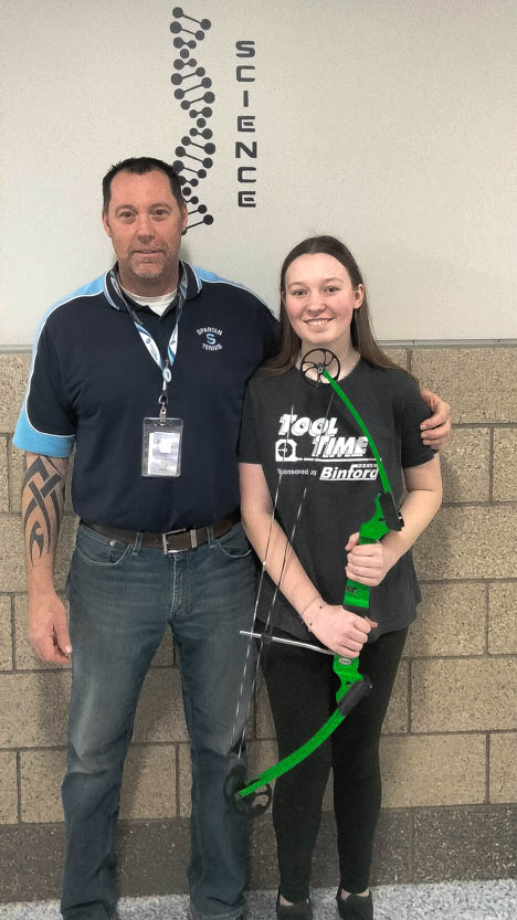  Biology teacher Pete Conley (left) stands with his freshman daughter
Emersyn Conley holding a bow in the science hall on May 5, 2024.
