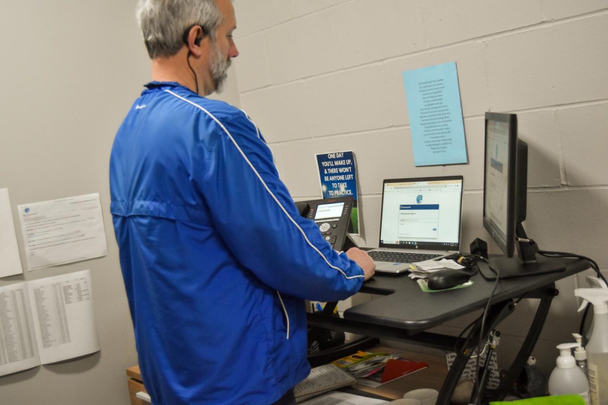 Dean Bryan Denninger stands at his desk in his office looking at PowerSchool on May 1, 2024.