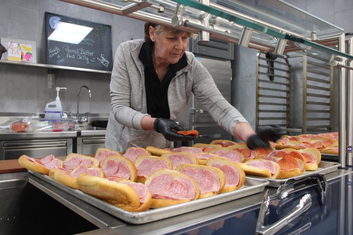 Cafeteria Worker Kym Nepper sets up the sub bar for the lunch period of May 17, 2024. she was having an enjoyable time even laughing when she called peperoni salami. (Kieran Hutchins)