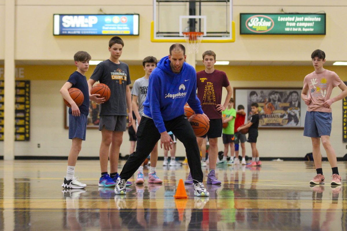 Coach Jake Smith demonstrates a drill during practice at Mertz Mortorelli gymnasium on April 24, 2024. Smith leads by example in order for players to be better at the sport that he loves. 