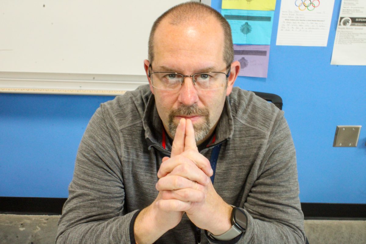 Science teacher Micheal Weinandt poses for the camera at his desk in room 1134 during fifth period on May 3, 2024.