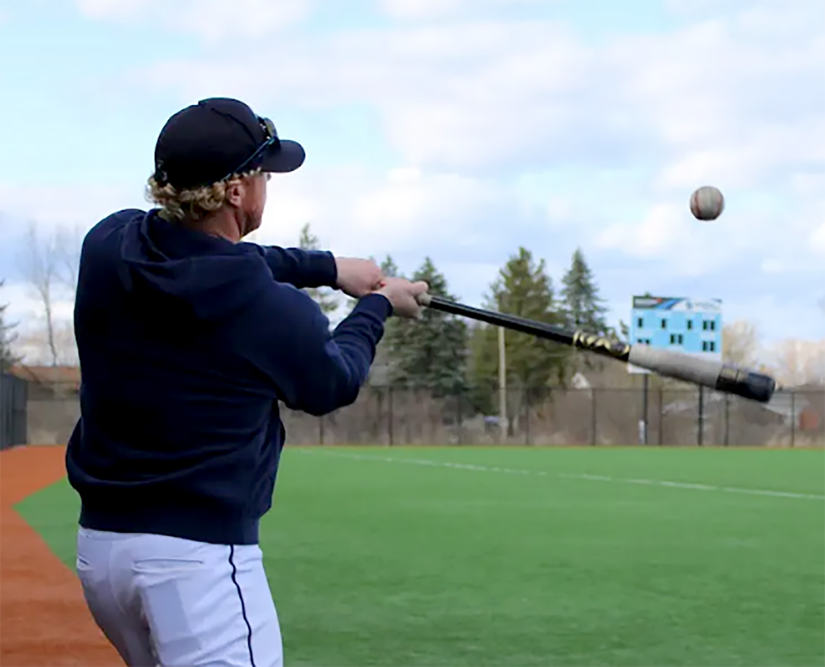 Head varsity baseball coach Ryan Hendry takes a swing at a ball on the baseball fields during practice on May 1, 2024. 
