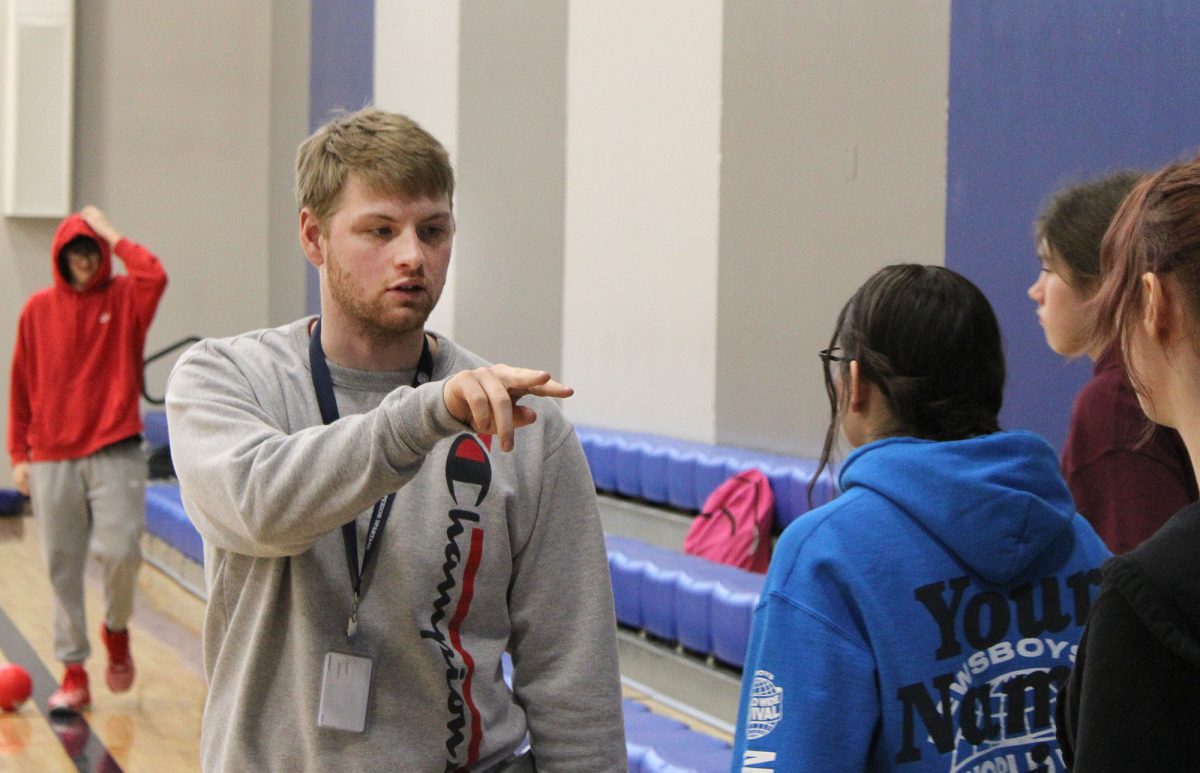 Gym teacher Gunner Johnson (middle) divides students for their game of dodgeball in the auxiliary gym during seventh period. Johnson is involved with students and athletes across the district. 