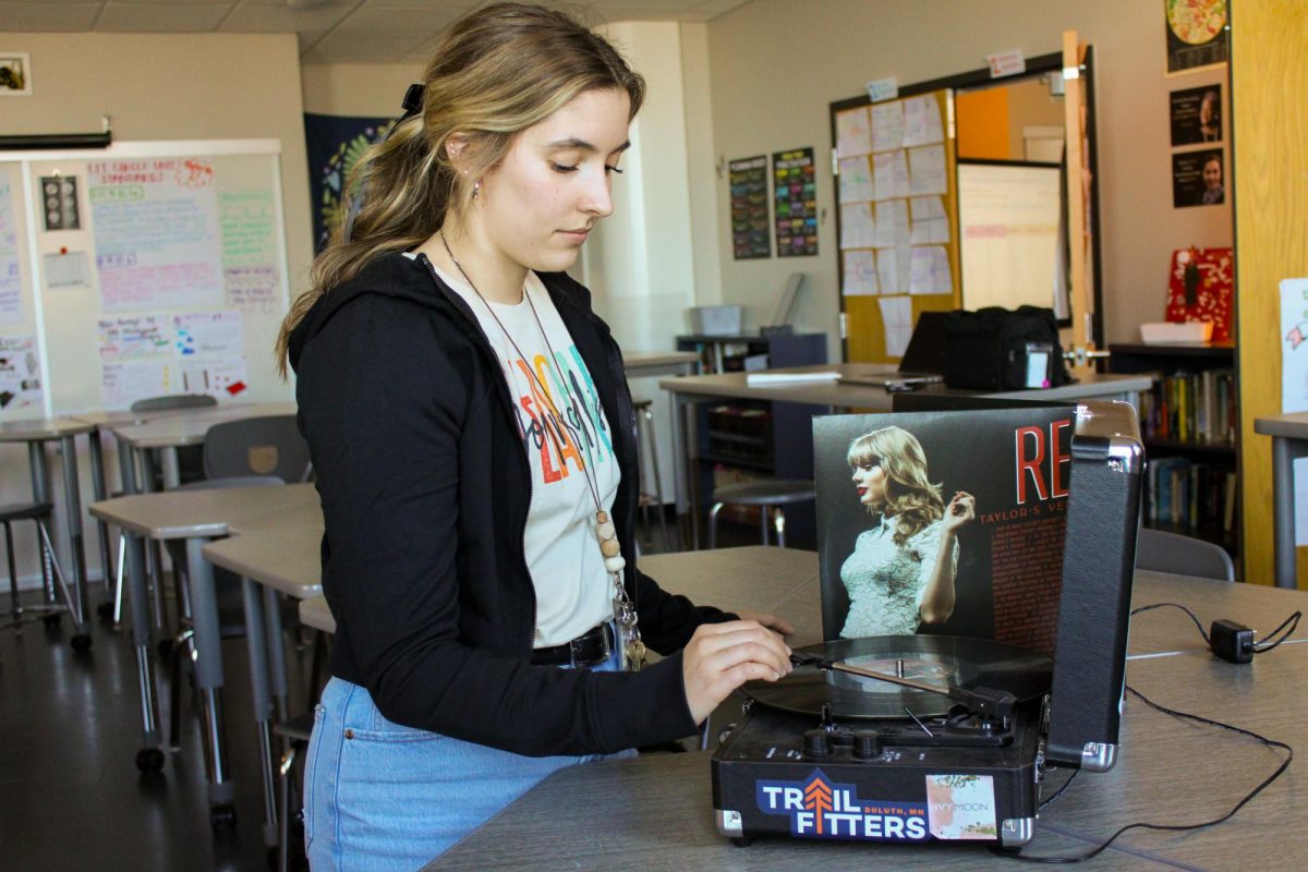 English teacher Elise Hintzman poses with a vinyl in her classroom on May 3, 2024. Along with her students, Hintzman is a big fan of music and Taylor Swift. 
