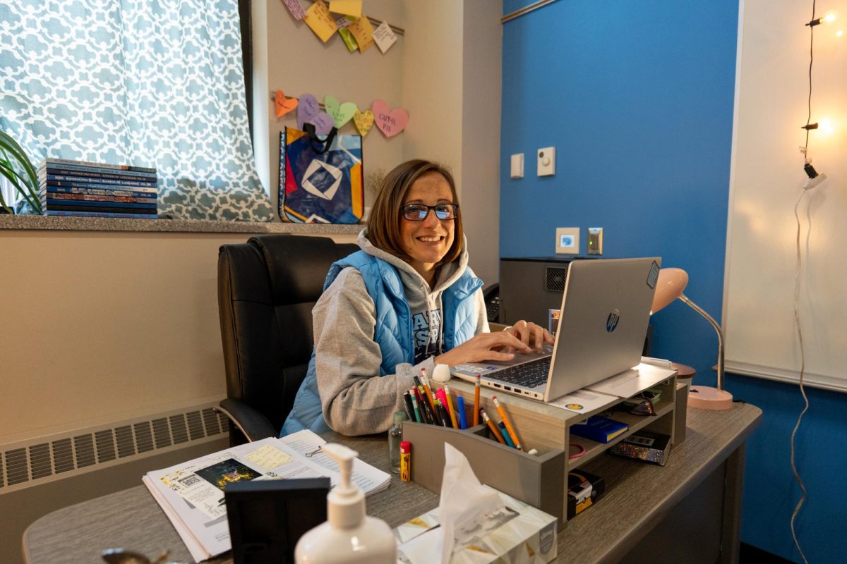 Business teacher Christa Kalin smiles at her desk in her room while working on her computer on May 3, 2024.