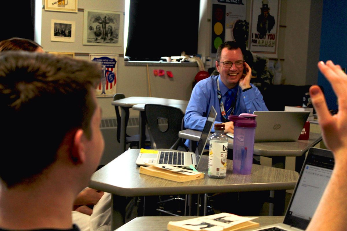 Social studies teacher Kyle Smith laughs with seniors in seminar circle on May 8, 2024. Engaging in conversation style teaching, Smith connects the class while pushing students to see new perspectives on topics.