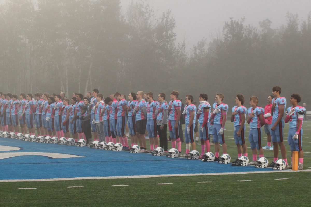 The Varsity football team stands for the national anthem on Sept. 13th at the NBC Spartan Sports Complex. 