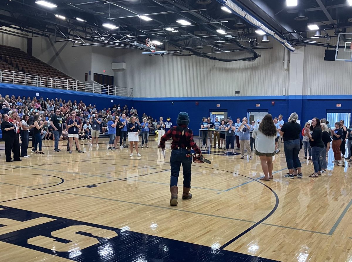 Biology teacher Lori Danz makes her entrance in the spartan arena as the host of the Wisconsin-themed trivia contest on Aug. 27, 2024.
