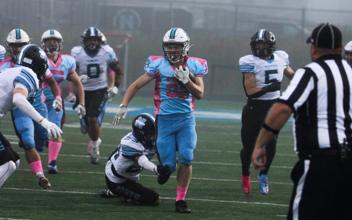 Junior Jayce Rue evades defenders as he carries the ball for a first down. the Spartans played the Eau Claire North Huskies in thier Tackle Cancer game on Sep. 13, 2024.