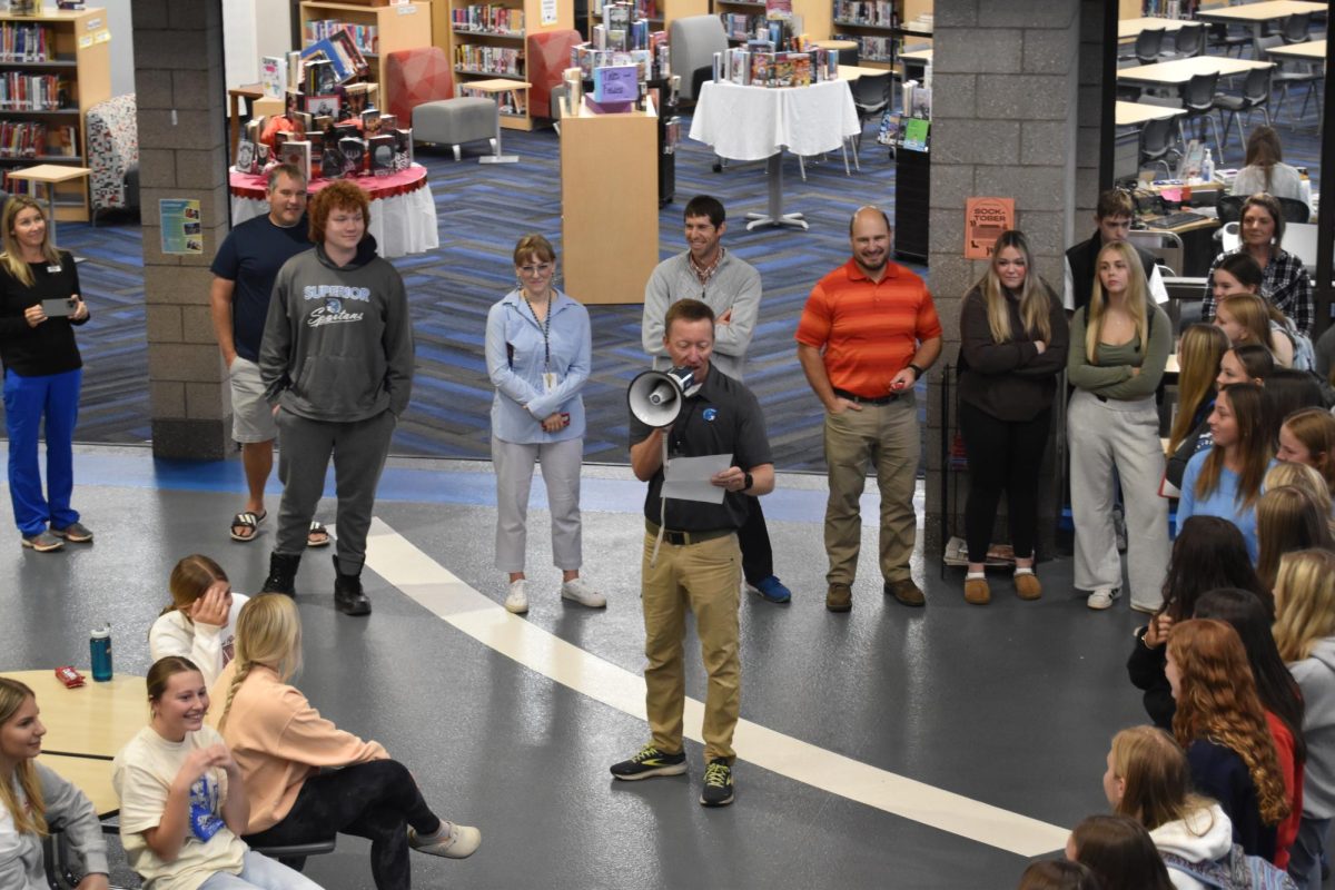 Tennis coach Mark Winkle gives a speech recognizing players Lily Clark and Greta Clark before heading to the Girls Tennis State Tournament on Oct. 16, 2024. Winkle praised the sisters for making it to state and for their undefeated regular season.