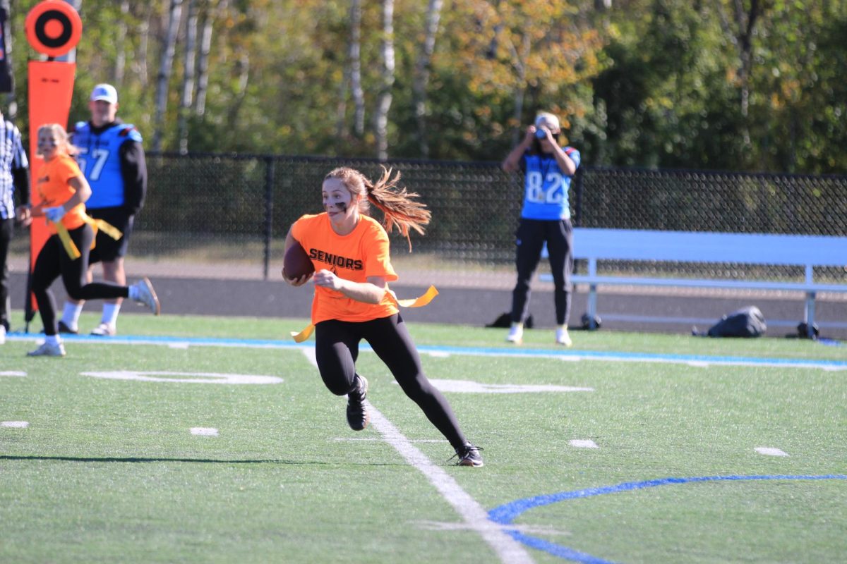 Ari Robillard runs the ball after the fake pass for a first down during the powderpuff tournament. Powderpuff took place during the day of homecoming on Oct. 4, 2024