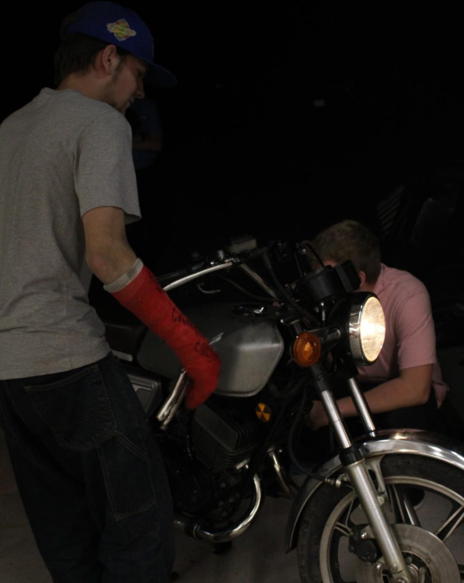 Junior Hunter Sanders (right) and senior Josh Herstad attempt to start Sander’s motorcycle outside of Herstad’s garage on Sept. 14.
